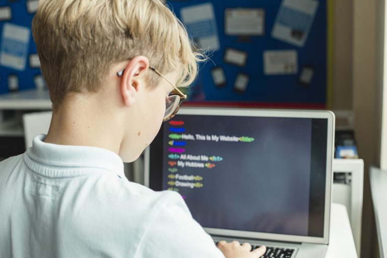 due bambine di spalle davanti al portatile che lavorano con scratch